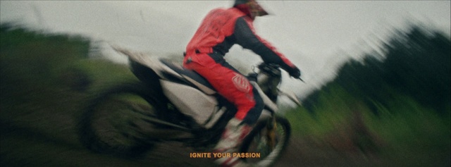 Video Reference: Vehicle, Motorcycle, Stunt performer, Recreation, Extreme sport, Cycling, Sports, Racing, Stunt, Motorcycling, Person, Riding, Grass, Wearing, Small, Man, Street, Sitting, Red, Bag, Laying, Woman, Cat, White, Young, Blurry