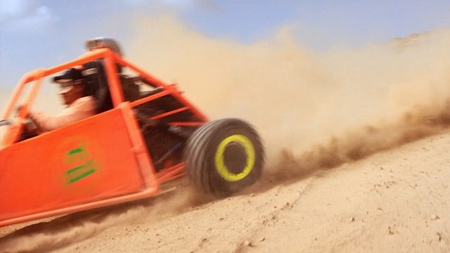 Video Reference: Vehicle, Off-road racing, Desert racing, Motor vehicle, Sand, Off-roading, Off-road vehicle, Automotive tire, Tire, Dust, Outdoor, Man, Air, Riding, Jumping, Flying, Small, Snow, Track, Yellow, Water, Red, Dirt, Boat, Doing, Train, Trick, Ocean, Wheel, Tractor, Land vehicle, Auto part, All-terrain vehicle, Truggy, Farm machine