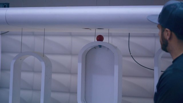 Video Reference: indoor, man, cap, wall structure, suspended, white frame, red ball, industrial, abstract, installation, modern, equipment