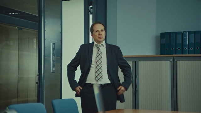 Video Reference: Suit, White-collar worker, Businessperson, Outerwear, Blazer, Formal wear, Room, Public speaking, Job, Tuxedo