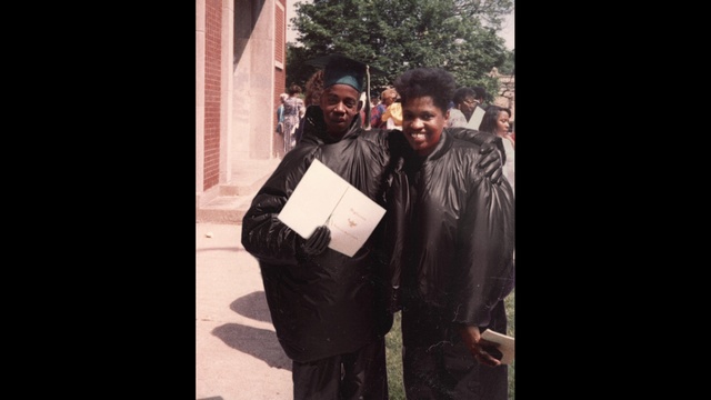Video Reference: Smile, Tree, Font, Hat, Event, Formal wear, Darkness, Academic dress, Street fashion, Fur