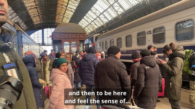 Video Reference: Train, Outerwear, Transport hub, Window, Jacket, Public space, City, Railway, Rolling stock, Crowd