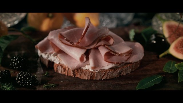 Video Reference: food, sandwich, open-faced, deli meat, bread, rustic, gourmet, appetizer, close-up, berries, figs, tabletop, still life, fresh, artisanal