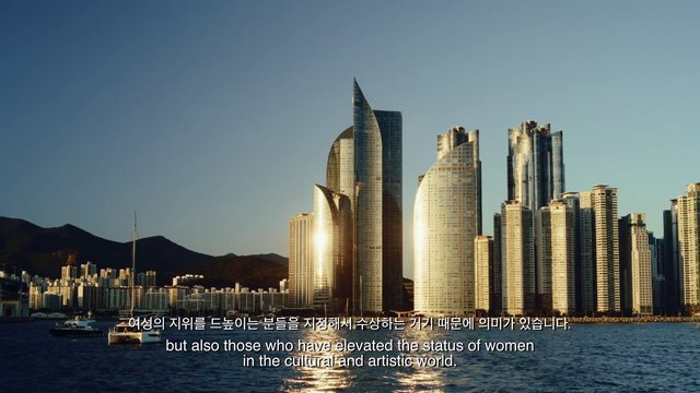 Video Reference: cityscape, skyline, skyscrapers, waterfront, sea, boats, mountains, golden hour, urban, architecture, travel, coastal, subtitles, modern city