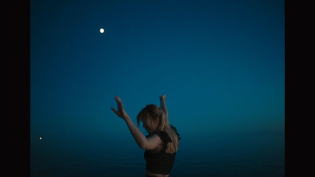 Video Reference: woman, dancing, arms raised, blue background, silhouette, performance, studio, night, motion, portrait, minimalism, bright light