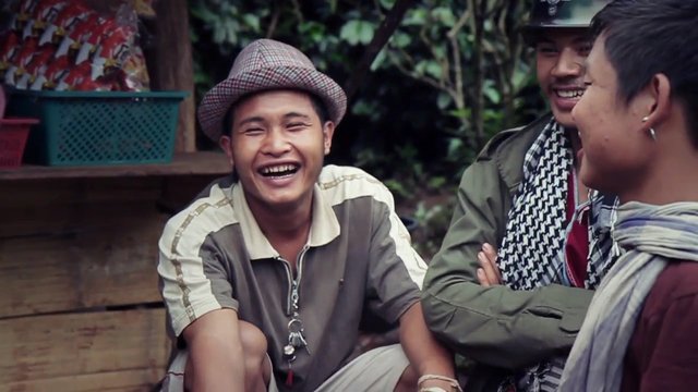Video Reference: men, outdoors, smiling, laughing, conversation, casual clothing, hat, group, friendship, seated, portrait, rustic setting, nature, social gathering