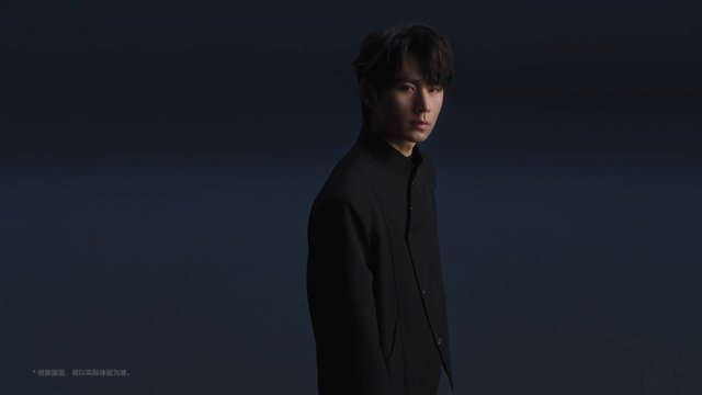 Video Reference: portrait, studio, man, young adult, dark clothing, low key lighting, fashion, dramatic lighting, gradient background, three quarter view, isolated subject, moody, minimalist, commercial, indoor