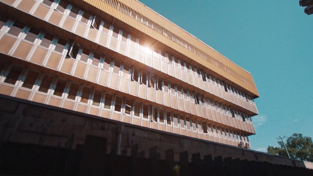 Video Reference: Building, Sky, Shade, Tower block, Urban design, Rectangle, Material property, Composite material, Condominium, Facade