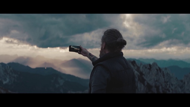 Video Reference: Cloud, Sky, Outerwear, Mountain, Flash photography, Cap, Standing, Highland, Sunlight, Atmospheric phenomenon