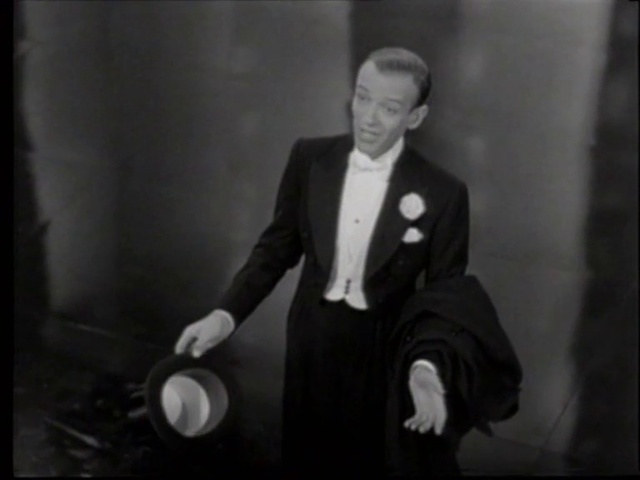 Video Reference: Suit trousers, Trousers, Coat, Gesture, Flash photography, Collar, Suit, Tie, Blazer, Chair