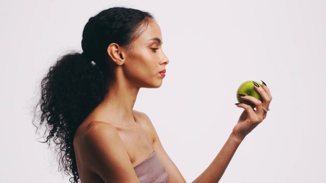 Video Reference: woman, profile, apple, fruit, portrait, studio, white background, beauty, elegant, hand holding, minimal, side view