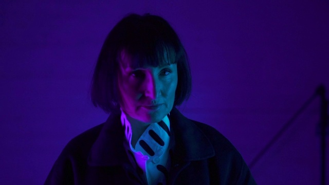 Video Reference: Outerwear, Mouth, Purple, Flash photography, Tie, Entertainment, Violet, Black hair, Audio equipment, Magenta