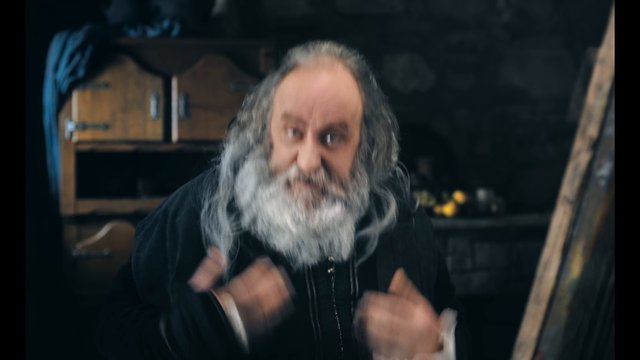 Video Reference: older man, bearded man, indoor, portrait, motion blur, dark clothing, close-up, rustic interior, looking at camera, people