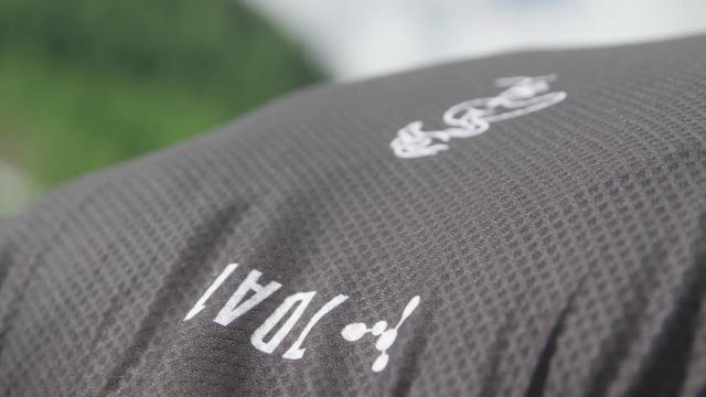 Video Reference: Sleeve, Grey, Gadget, Font, Automotive design, Electronic device, Personal protective equipment, Close-up, Logo, Sportswear