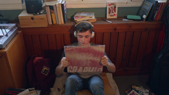 Video Reference: Jeans, Wood, Chair, Event, Flooring, T-shirt, Lap, Room, Reading, Folk instrument