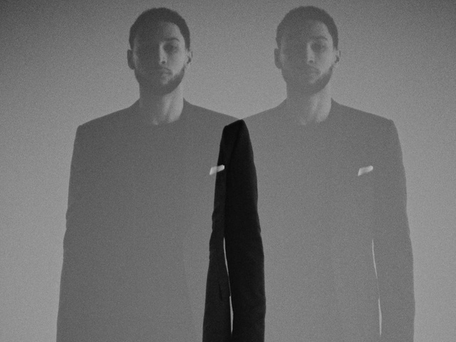 Video Reference: Hair, Head, Neck, Flash photography, Jaw, Sleeve, Lighting, Standing, Gesture, Grey