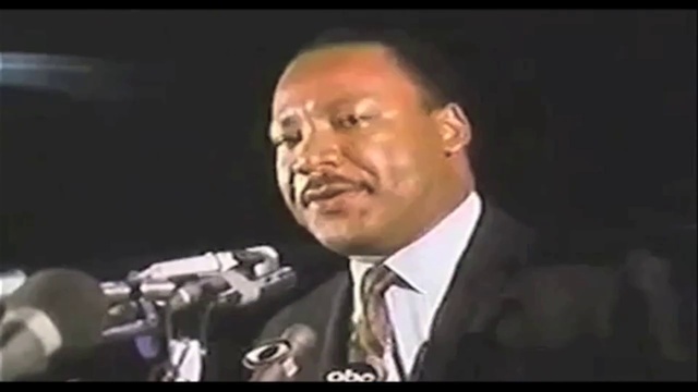 Video Reference: Tie, Jaw, Collar, Microphone, Event, Suit, Music artist, Formal wear, Spokesperson, Pleased