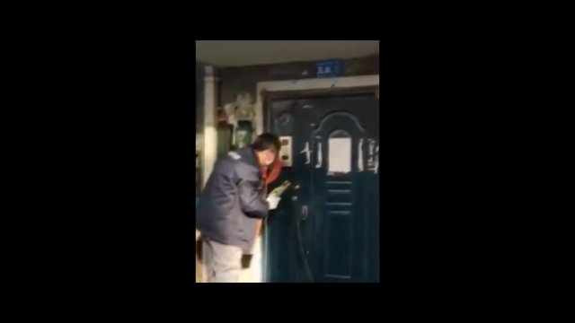 Video Reference: person, door, entryway, lock, doorbell, winter jacket, indoor, house entrance, leaning, close-up, dim light