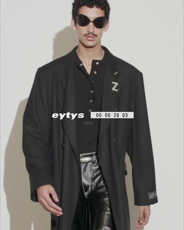 Video Reference: Face, Outerwear, Black, Fashion, Dress shirt, Neck, Street fashion, Sleeve, Overcoat, Waist