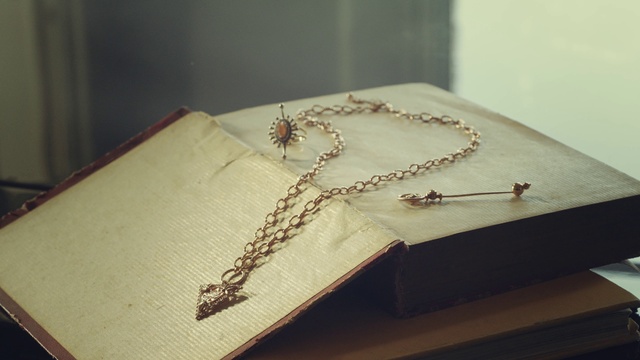 Video Reference: Brown, Wood, Textile, Body jewelry, Rectangle, Beige, Material property, Font, Jewellery, Religious item