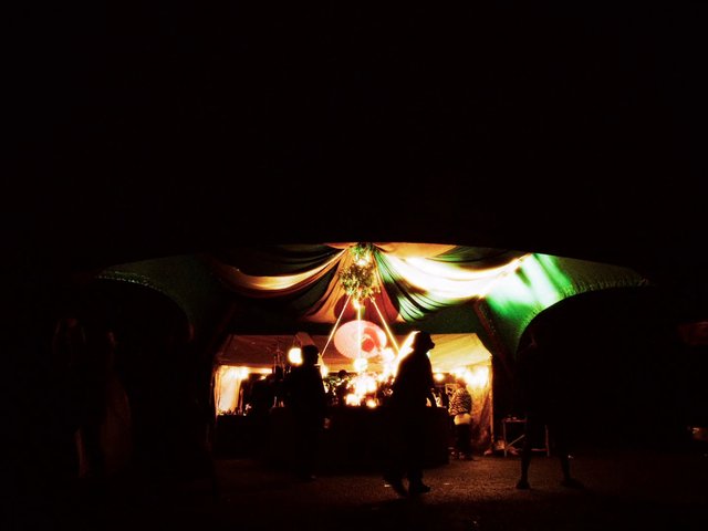 Video Reference: night, silhouette, tent, booth, festival, event, lighting, crowd, outdoor, draped fabric, decorated, nightlife
