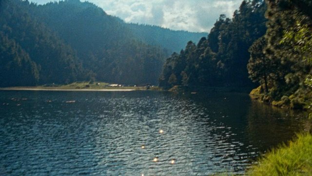 Video Reference: lake, mountains, forest, nature, landscape, water, reflection, cloudy sky, outdoors, scenic, wilderness, shoreline, trees, tranquil