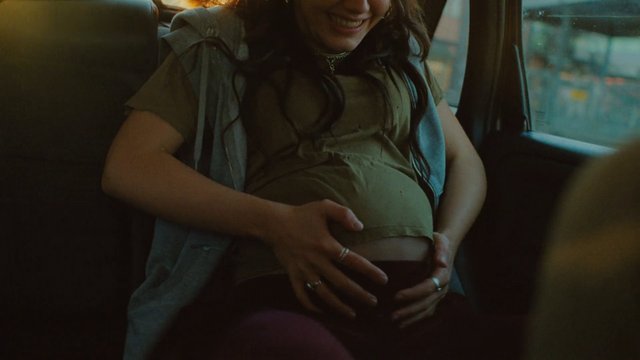 Video Reference: pregnant, woman, car interior, smiling, hands on belly, portrait, expecting mother, travel, window light, lifestyle