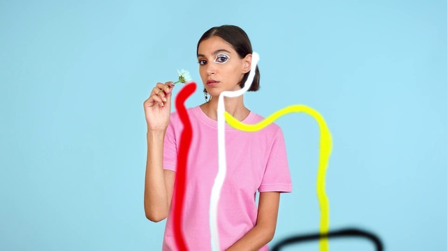 Video Reference: Lip, Shoulder, Eyelash, Neck, Human body, Sleeve, Gadget, Gesture, Audio equipment, Happy