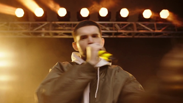 Video Reference: Light, Sleeve, Musician, Gesture, Jacket, Audio equipment, Microphone, Music, Entertainment, Flash photography