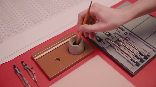Video Reference: Hand, Textile, Paint, Office supplies, Wood, Finger, Table, Writing implement, Material property, Font