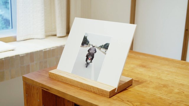 Video Reference: photo, motorcycle, rider, indoor, table, framed, wooden, window, room, display, still life