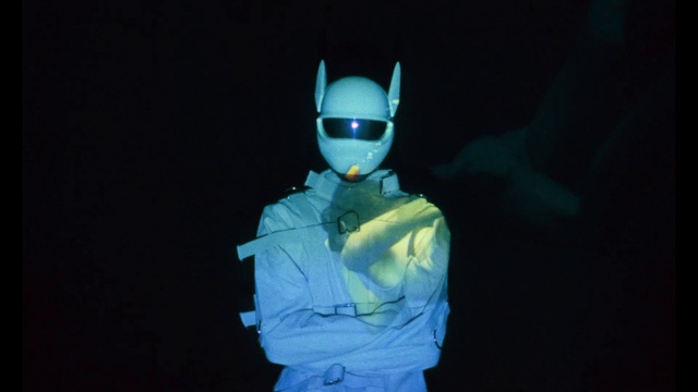 Video Reference: Glove, Sleeve, Gesture, Personal protective equipment, T-shirt, Eyewear, Electric blue, Recreation, Fictional character, Event