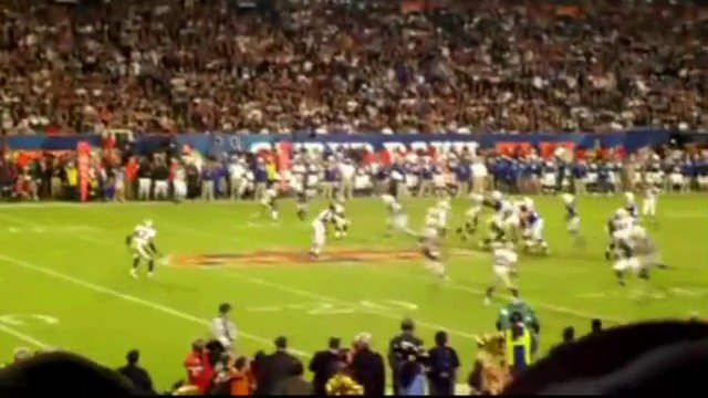 Video Reference: american football, sports, stadium, game action, field, players, crowd, outdoor, competition, wide shot, night game, spectators