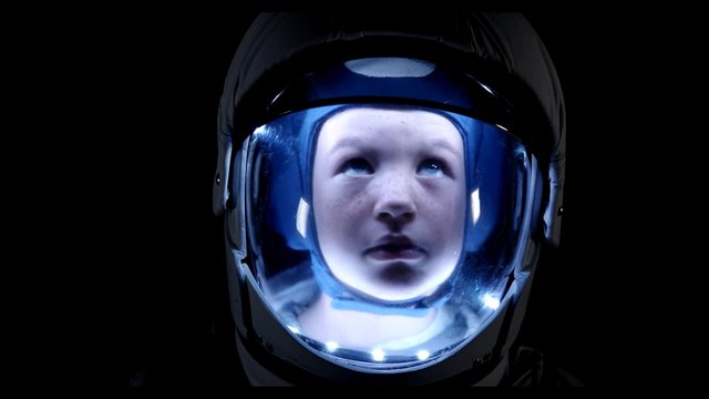 Video Reference: helmet, visor, astronaut, space suit, close-up, portrait, dark background, blue lighting, reflection, futuristic, sci-fi, child, face, protective gear