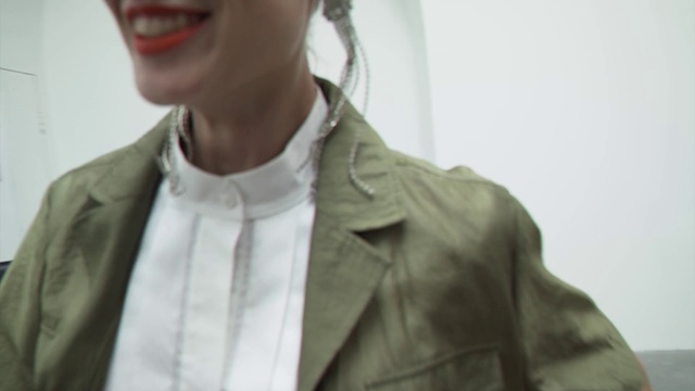 Video Reference: Dress shirt, Smile, Neck, Jaw, Sleeve, Eyewear, Gesture, Street fashion, Grey, Collar