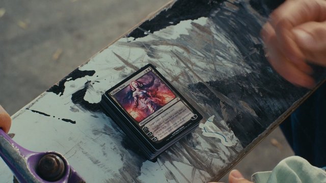 Video Reference: trading cards, card game, tabletop, hands, stack of cards, close-up, indoor, game play, artwork, surface, deck, collectible
