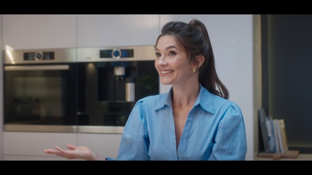 Video Reference: Television presenter, Smile, Gesture, Sleeve, White-collar worker, Flash photography, Display device, Electronic device, Electric blue, Multimedia