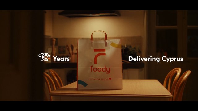 Video Reference: food delivery, delivery bag, dining table, kitchen, interior, branded bag, advertisement, warm lighting, chairs, home, takeout, package, promotional text, evening, restaurant delivery
