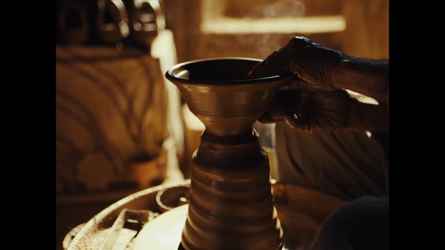 Video Reference: pottery, ceramics, clay, potter, hands, gloves, pottery wheel, craft, artisan, workshop, close-up, handmade, vessel, shaping, studio, warm light
