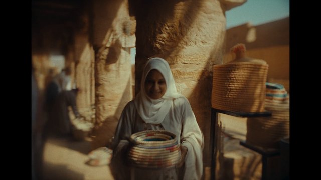 Video Reference: woman, headscarf, market, woven baskets, handicraft, artisan, outdoor, shopping, traditional goods, stall, baskets, portrait, warm light