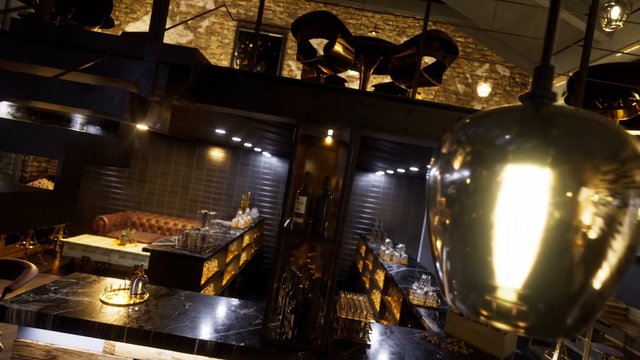 Video Reference: bar, lounge, interior, luxury, upscale, restaurant, nightlife, marble, leather, bottles, glassware, lighting, modern, hospitality, warm tones, empty