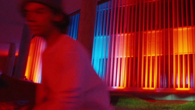 Video Reference: Visual effect lighting, Entertainment, Magenta, Fun, Electric blue, T-shirt, Neon, Event, Display device, Facial hair