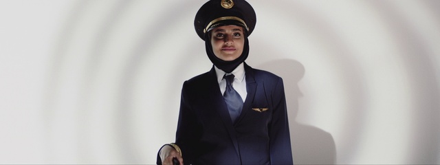 Video Reference: Hat, Dress shirt, Tie, Sleeve, Peaked cap, Gesture, Costume hat, Collar, Headgear, Cap