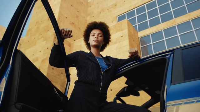 Video Reference: Hood, Flash photography, Gesture, Automotive design, Automotive exterior, Vehicle door, Tints and shades, Street fashion, Electric blue, White-collar worker