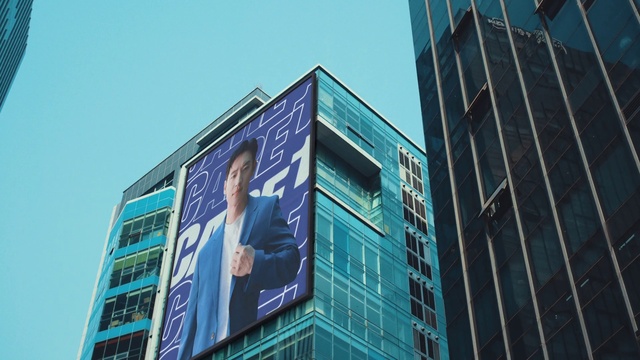 Video Reference: Sky, Building, Billboard, Window, Tower block, Skyscraper, Commercial building, Facade, City, Electric blue
