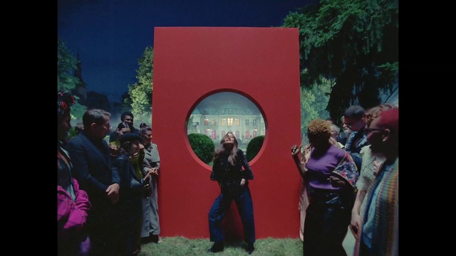 Video Reference: Entertainment, Art, Magenta, Leisure, Event, Display device, Stage, Suit, Tree, Visual arts