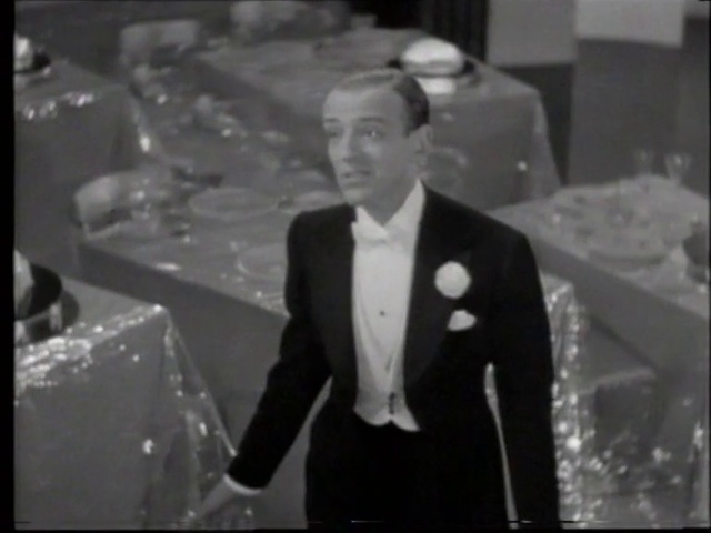 Video Reference: Flash photography, Coat, Black-and-white, Gesture, Style, Collar, Suit, Tie, Blazer, Formal wear