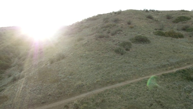 Video Reference: Mountain, Sky, Slope, Plant, Grassland, Landscape, Road, Grass, Valley, Plateau