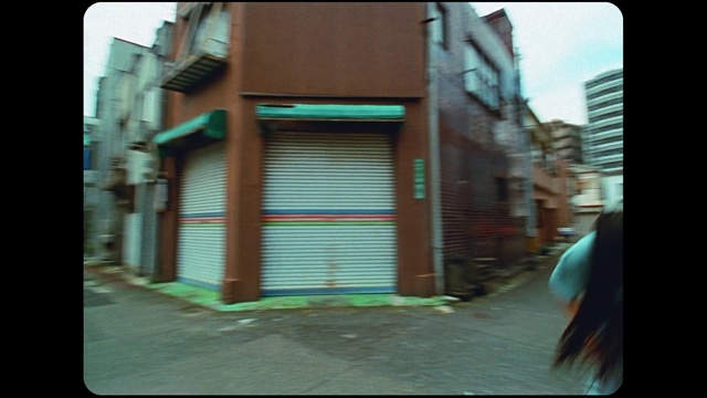 Video Reference: Black, Rectangle, Building, Architecture, Wall, Tints and shades, Font, Facade, Human settlement, Magenta