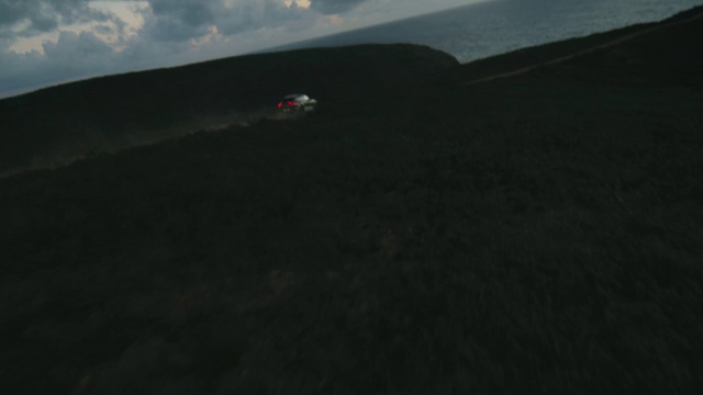 Video Reference: Cloud, Sky, Slope, Vehicle, Asphalt, Terrain, Plain, Landscape, Grassland, Road